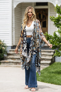woman wearing Lightweight Kimono
in shades of black, brown, light blue, gold in an Abstract Pattern 
Open Front
Side Slit