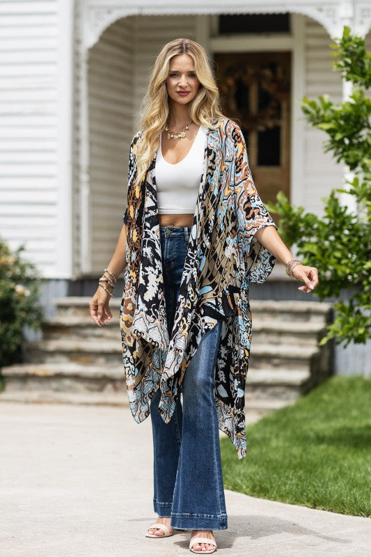 woman wearing Lightweight Kimono
in shades of black, brown, light blue, gold in an Abstract Pattern 
Open Front
Side Slit