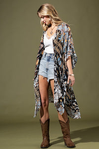 woman wearing Lightweight Kimono
in shades of black, brown, light blue, gold in an Abstract Pattern 
Open Front
Side Slit