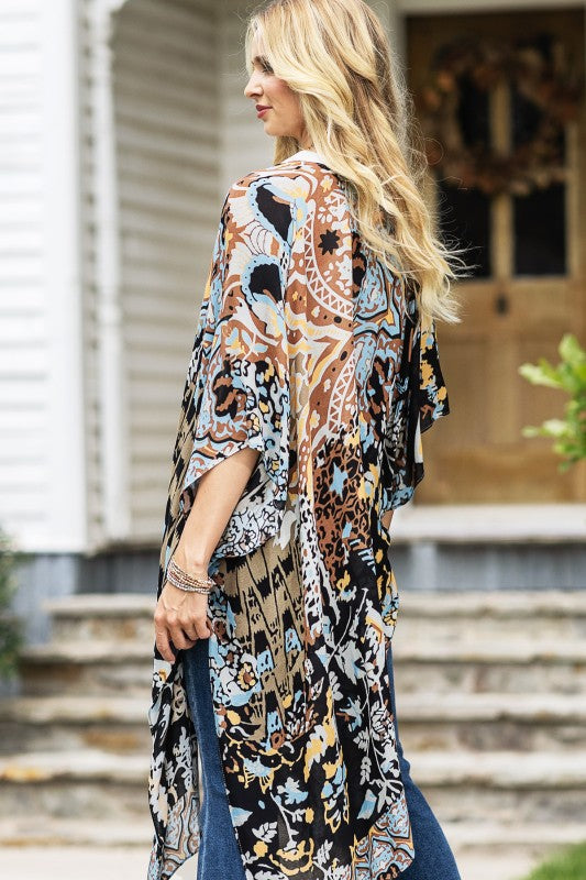 woman wearing Lightweight Kimono
in shades of black, brown, light blue, gold in an Abstract Pattern 
Open Front
Side Slit