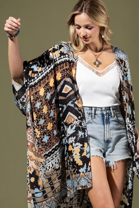 woman wearing Lightweight Kimono
in shades of black, brown, light blue, gold in an Abstract Pattern 
Open Front
Side Slit