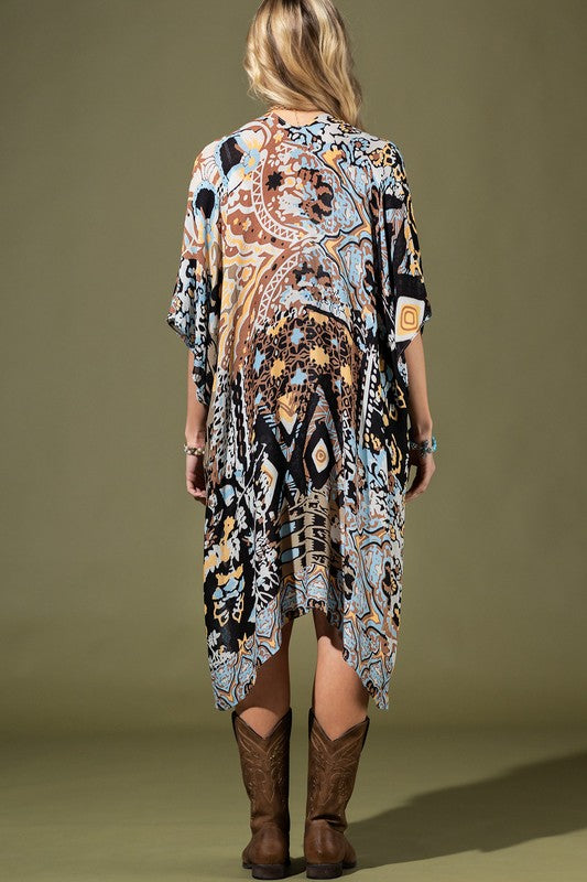 woman wearing Lightweight Kimono
in shades of black, brown, light blue, gold in an Abstract Pattern 
Open Front
Side Slit