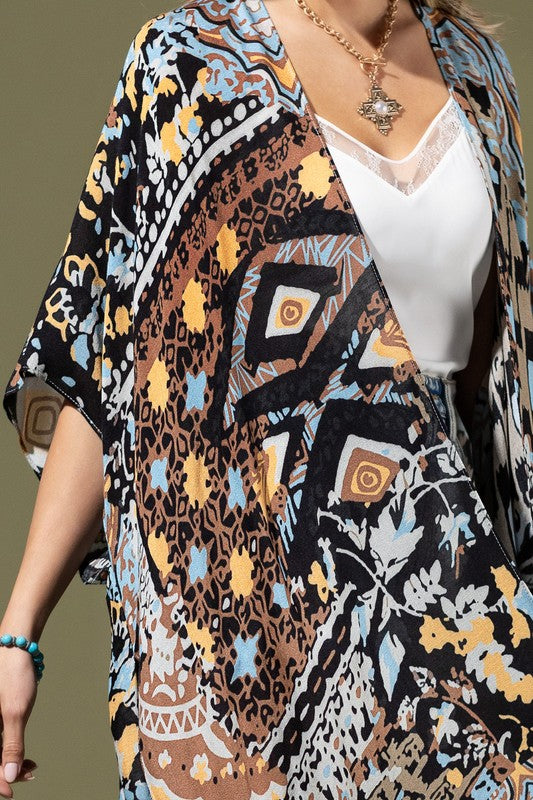 woman wearing Lightweight Kimono
in shades of black, brown, light blue, gold in an Abstract Pattern 
Open Front
Side Slit
