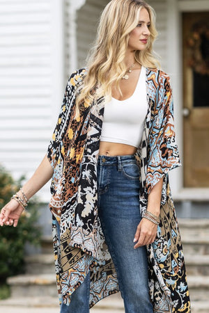 woman wearing Lightweight Kimono
in shades of black, brown, light blue, gold in an Abstract Pattern 
Open Front
Side Slit