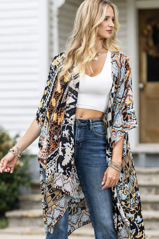 woman wearing Lightweight Kimono
in shades of black, brown, light blue, gold in an Abstract Pattern 
Open Front
Side Slit