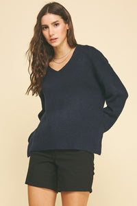 female wearing a V-Neck Navy Pullover with long sleeves and ribbed cuffs and hem