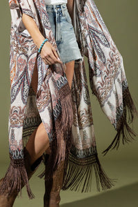 woman wearing Lightweight Kimono
Mixed Paisley Pattern Print in shades of beige, orange, blues
Long Fringe at the Bottom
Open Front
Side Slits
