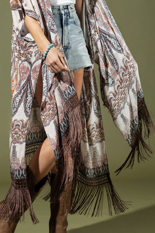 woman wearing Lightweight Kimono
Mixed Paisley Pattern Print in shades of beige, orange, blues
Long Fringe at the Bottom
Open Front
Side Slits