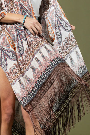 woman wearing Lightweight Kimono
Mixed Paisley Pattern Print in shades of beige, orange, blues
Long Fringe at the Bottom
Open Front
Side Slits