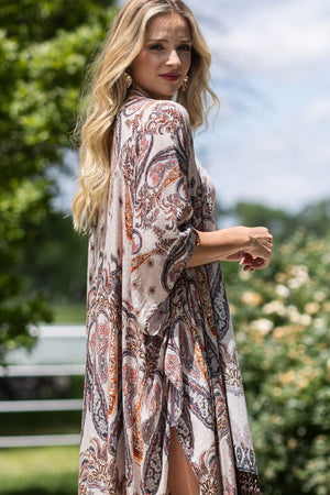 woman wearing Lightweight Kimono
Mixed Paisley Pattern Print in shades of beige, orange, blues
Long Fringe at the Bottom
Open Front
Side Slits