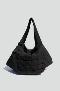 Black quilted tote bag with adjustable "seatbelt" strap, zipper closure and interior wall pockets