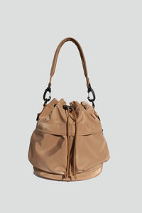 Sand nylon bucket bag with  drawstring closure, two detachable strap options (long strap, short handle) with exterior pockets in front.