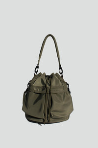 Army Green nylon bucket bag with  drawstring closure, two detachable strap options (long strap, short handle) with exterior pockets in front.