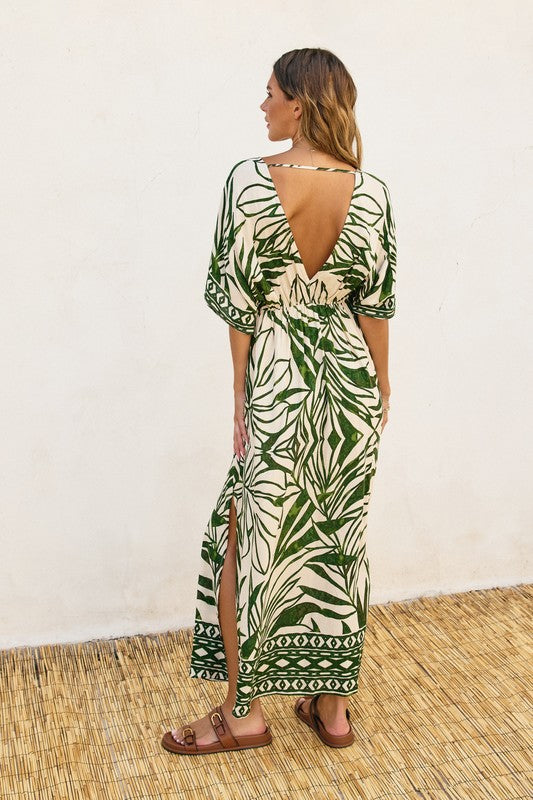 DOLMAN SLEEVE MAXI DRESS in a green graphic floral print on a natural background