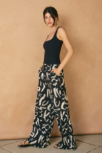 WIDE LEG, BLACK & WHITE GEO PRINT PANTS WITH IN-SEAM FRONT POCKETS.  FRONT ZIPPER AND BUTTON CLOSURE.