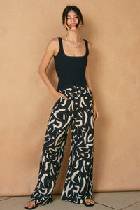 WIDE LEG, BLACK & WHITE GEO PRINT PANTS WITH IN-SEAM FRONT POCKETS.  FRONT ZIPPER AND BUTTON CLOSURE.