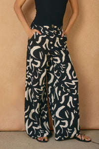 WIDE LEG, BLACK & WHITE GEO PRINT PANTS WITH IN-SEAM FRONT POCKETS.  FRONT ZIPPER AND BUTTON CLOSURE.