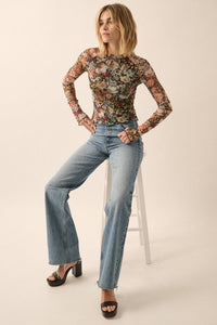 Floral print Semi-Sheer mesh top with long sleeves with thumbholes, a high neckline and
Ruffled Stitching at Hemline and wrist.  Bodice is lined.