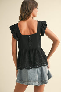 BACK OF BLACK EYELET PEPLUM BOTTOM SLEEVELESS BLOUSE WITH THREE BUTTON CLOSURE IN BACK