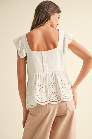 BACK OF WHITE EYELET PEPLUM BOTTOM SLEEVELESS BLOUSE WITH THREE BUTTON CLOSURE IN BACK