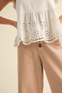 BOTTOM HALF OF WHITE EYELET PEPLUM BOTTOM SLEEVELESS BLOUSE