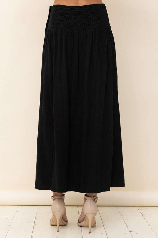 Linen blend maxi skirt in black with functional faux wooden buttons at side waist.  Hidden side pockets.